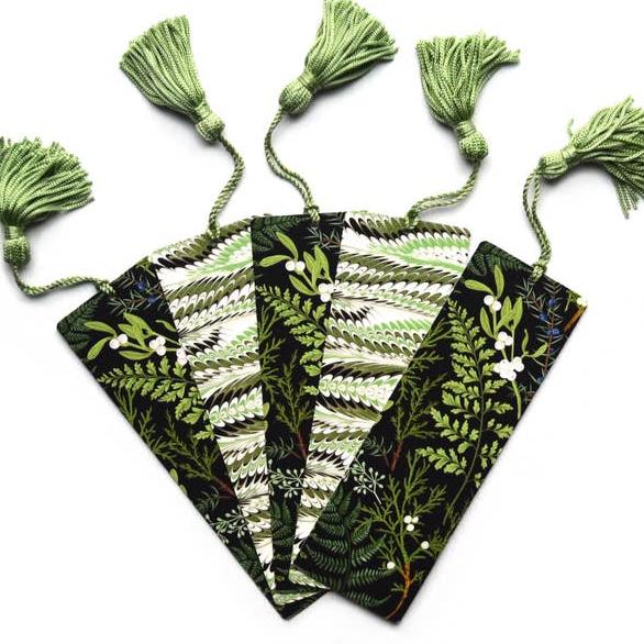 Five botanical bookmarks with fern motifs on dark backgrounds and green tassels