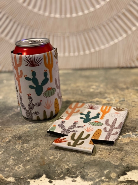 White desert cactus print koozie around a red can with a matching cactus sleeve beside it