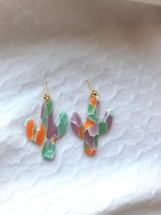 Two multicolor cactus earrings on gold hooks with orange green and purple panels