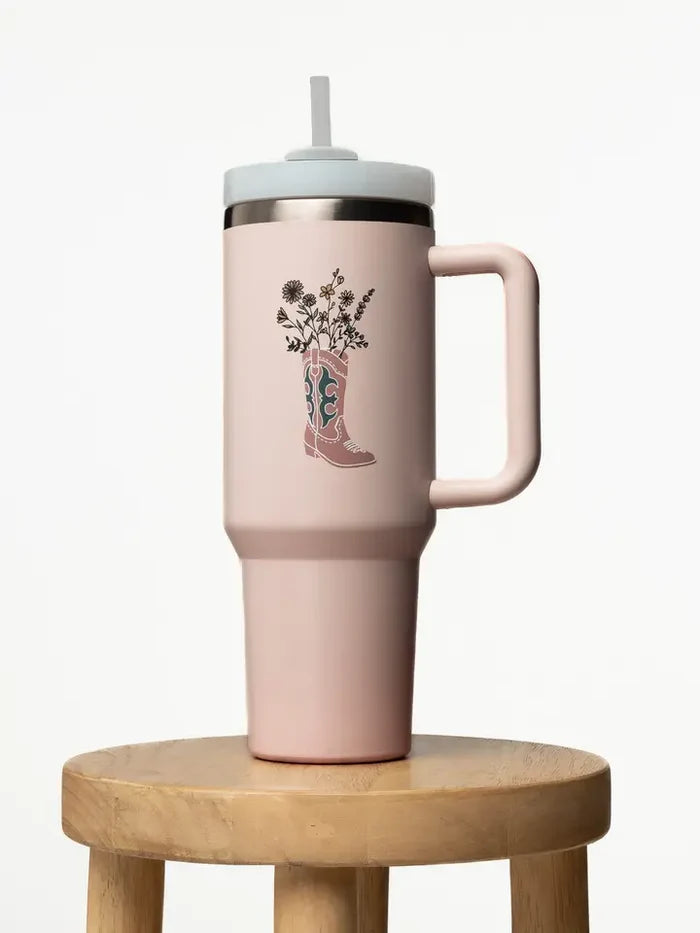 Light pink insulated tumbler with a floral bouquet emerging from a cowboy boot illustration