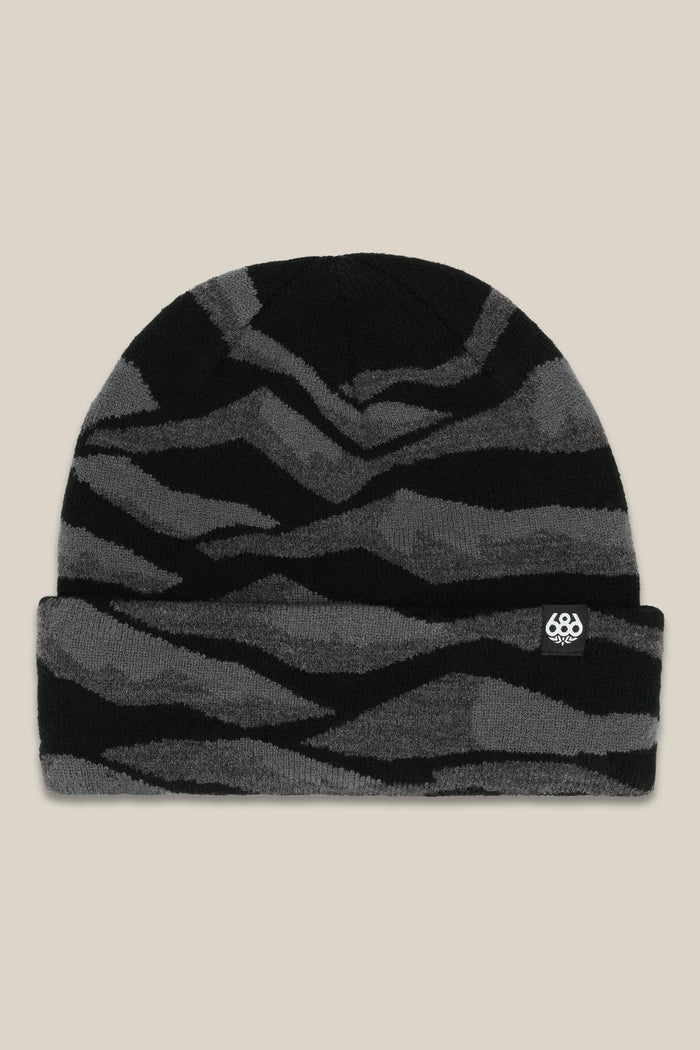 The 686 Summit Beanie by 686 features a black and dark gray wavy striped design with a small white logo patch on the folded brim, shown on a beige background‚Äîideal for adventurous climbs or epic descents.