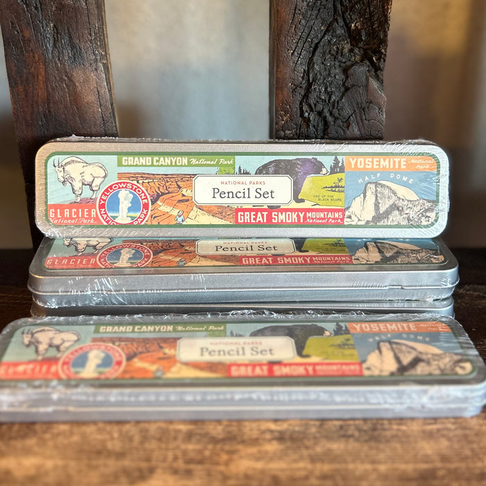 Vintage National Parks Pencil Set tin with two illustrated pencils in front against a wooden backdrop.