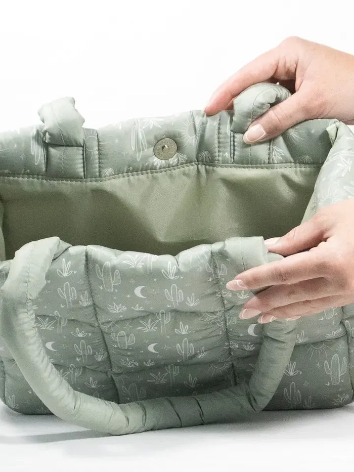 Interior view of the Cactus Cloud quilted puffer tote showing a magnetic snap and padded lining.