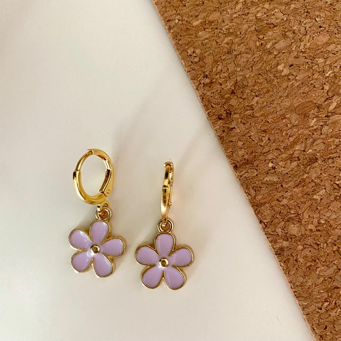 Gold hoop earrings with lavender enamel five-petal flower charms and a small central gem