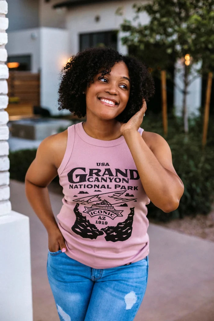 Woman wearing a pink Grand Canyon rib tank top with a bold National Park graphic outdoors.
