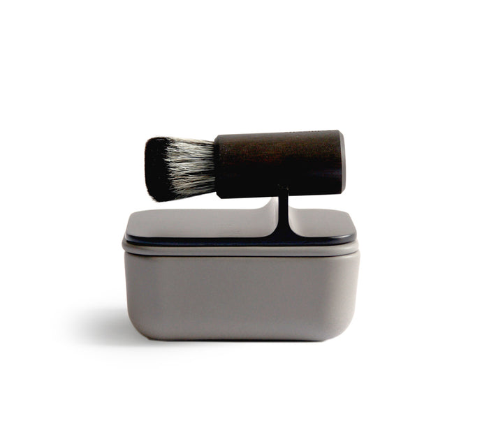 Silhouetted image of hard Jiva face cleansing and shaving series with porcelain bowl and walnut, boar bristle, and goat hair brush by Shaquda against white background.
