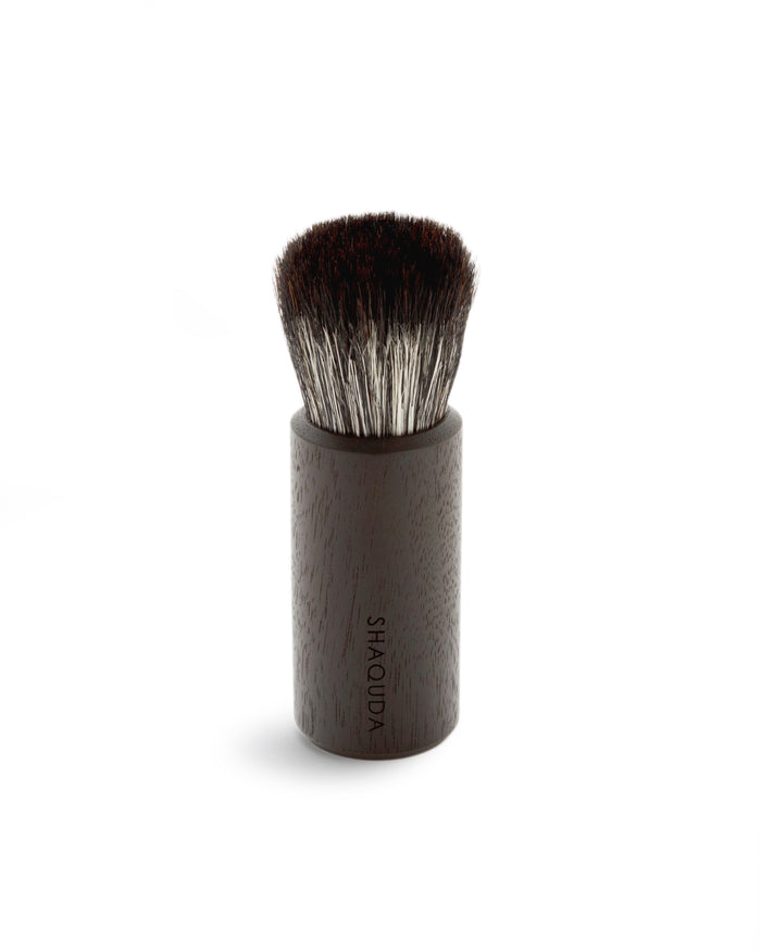 Silhouetted image of hard Jiva face cleansing and shaving series walnut, boar bristle, and goat hair brush by Shaquda against white background.