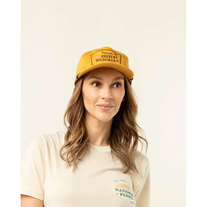 Mustard yellow cap with patch reading Only you can prevent wildfires worn by a model.