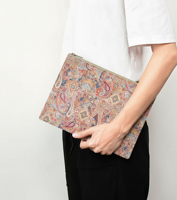 Paisley print leather zip pouch held in hand, rectangular clutch shape