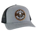Gray curved-brim trucker hat with a circular embroidered patch showing a skull and orange desert roses