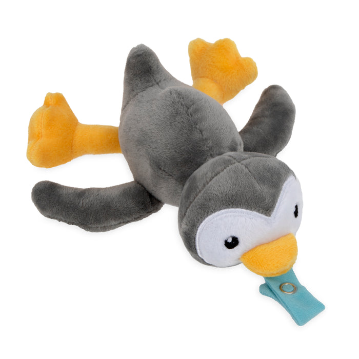 The Snuggleez Pacifier and Clip Combo Set features a gray and white plush penguin with yellow feet and beak, lying flat and holding a blue natural FLEX pacifier in its beak to soothe babies aged 0-6 months.