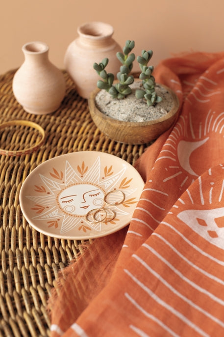 Round Soleil Sun Trinket Tray dish with a white sun face on peach background, styled with pottery and textile.