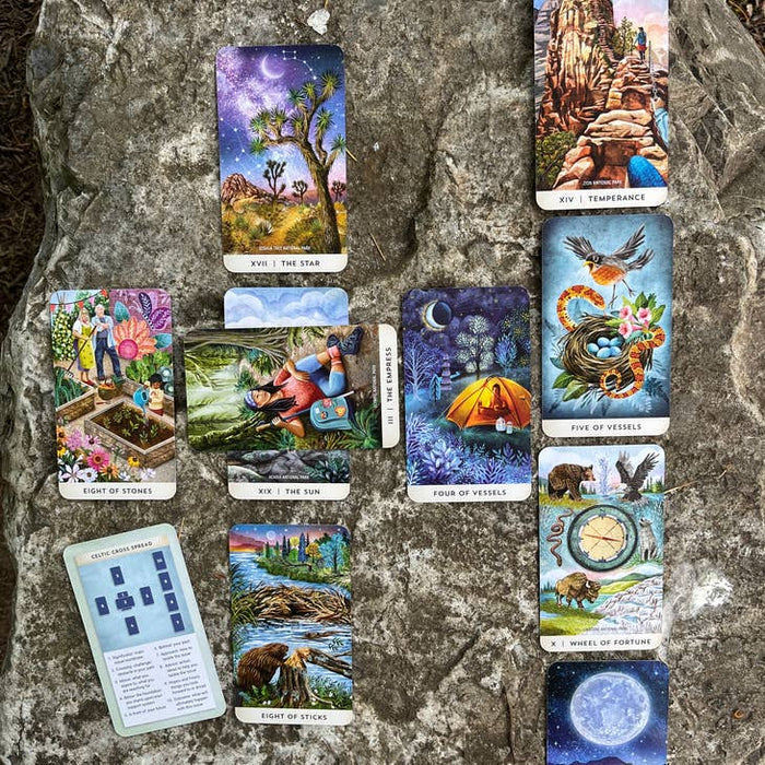 Colorful outdoor tarot cards spread across a rocky surface