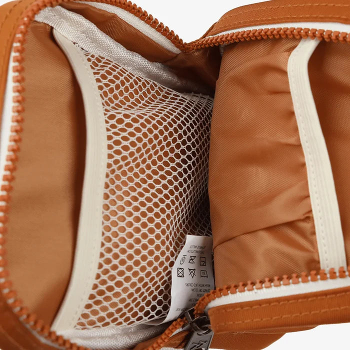 Interior view of orange Thread crossbody bag showing a white mesh pocket and zipper panel