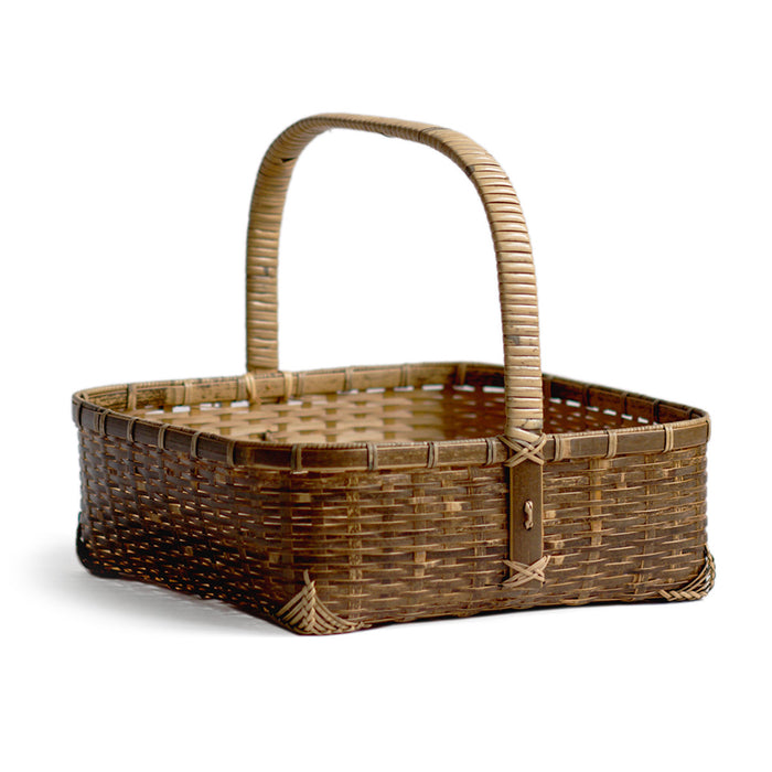 Silhouetted angled image of square toradake bread basket with handle by Kohchosai Kosuga against white background.