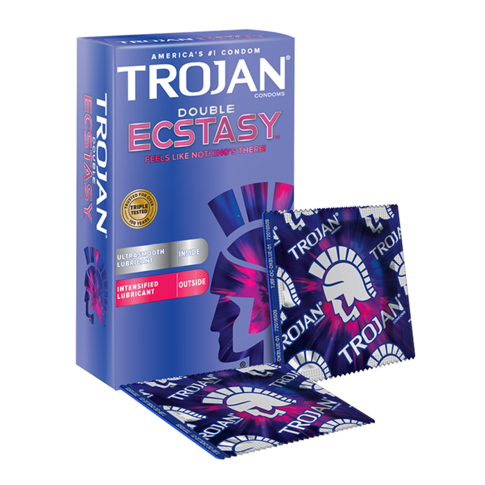 A 3D perspective view of the blue Trojan Double Ecstasy condom box alongside two individual foil wrappers. The wrappers feature a repeating pattern of the Trojan logo and helmet graphic in blue, white, and pink. The box design is consistent with the front view, showing the "Double Ecstasy" branding and the "Triple Tested" gold seal of quality.