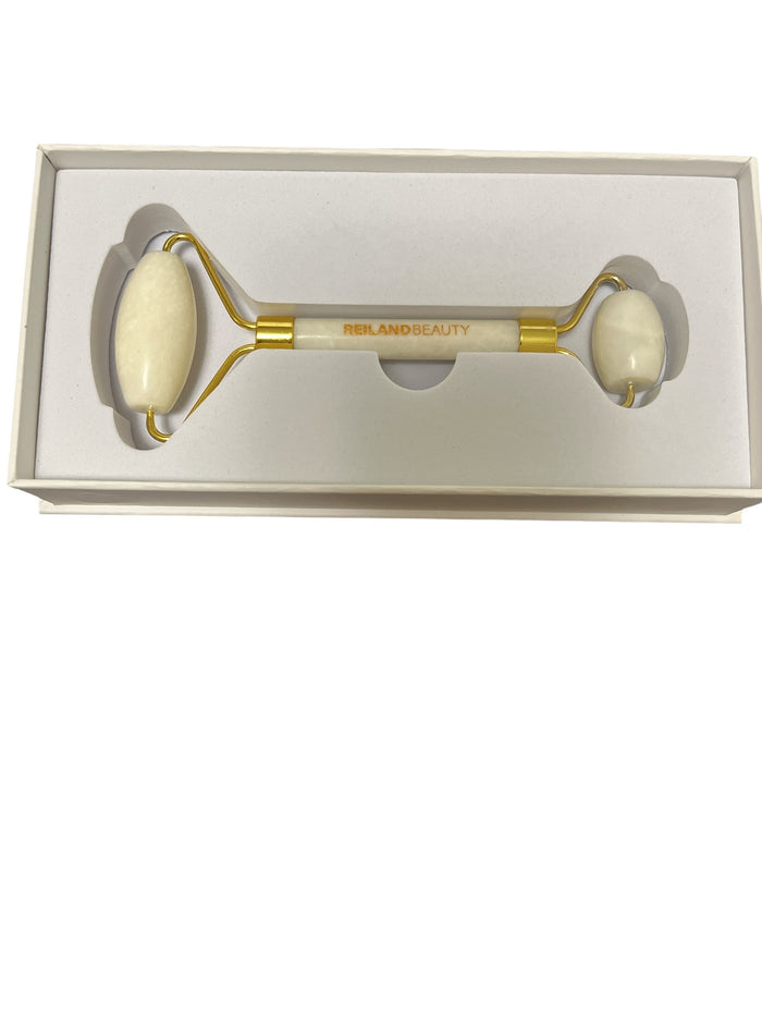Beauty roller with gold accents in a white box on a white background